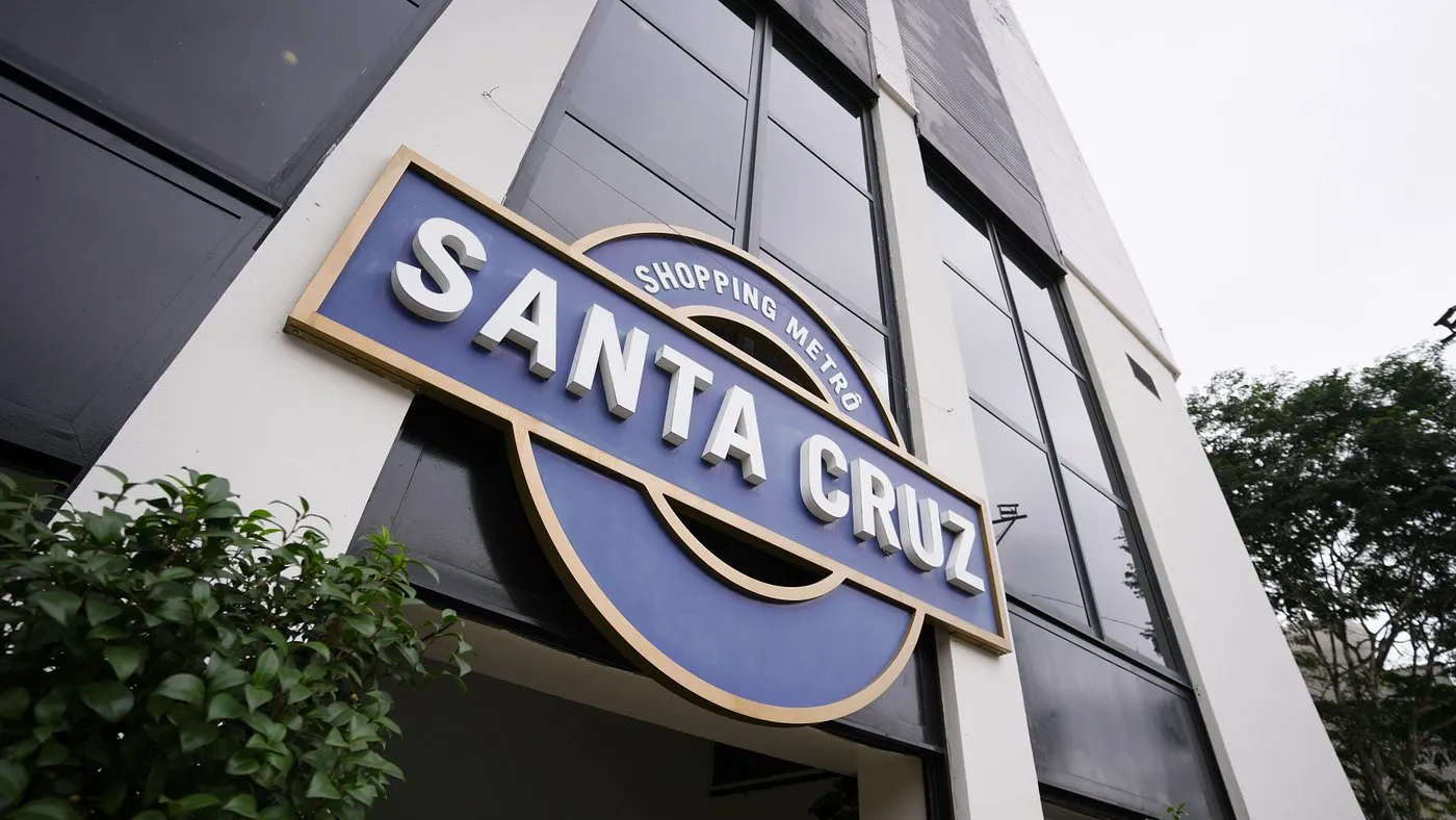 Letreiro azul e dourado do Shopping Metrô Santa Cruz na fachada do prédio